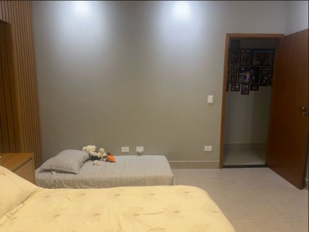 Quarto real: a cama e a porta com o mural de fotos